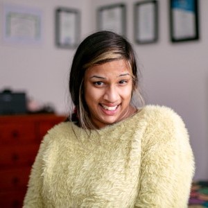 An image of Jerusha smiling in her bedroom
